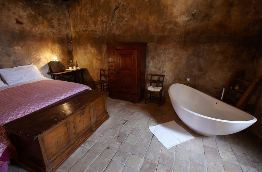 A double room in the Albergo Diffuso Sextantio in Santo Stefano di Sessanio, Abruzzo, Italy. As the original buildings had no functioning bathrooms, modern furnishings like this bath tub have been placed in a way as to reduce their impact on the space as much as possible to retain the original feel.